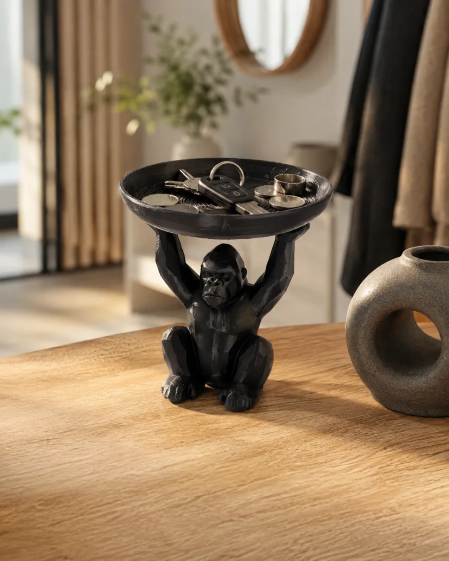 Sort 10 cm høy 3D-printet gorillafigur som sitter med armene hevet og holder en rund oppbevaringsskål over hodet.