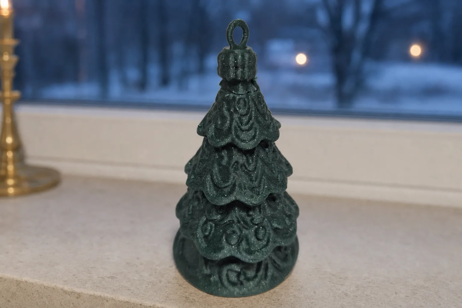 Mørkegrønn julepynt formet som et lagdelt, ornamentert juletre med oval opphengsløkke, fotografert mot hvit bakgrunn.