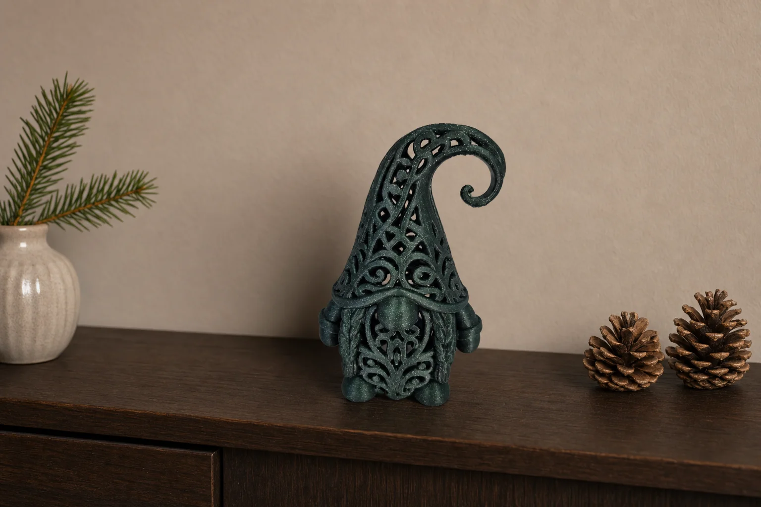 Mørkegrønn glitrende julefigur formet som en nisse med åpent ornamentmønster, rund nese, skjegg og høy spiralformet lue.